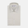 View 1 of product The Turnbull & Asser Cream Herringbone Superfine Cotton Shirt features a T&A collar and 3-button cuffs, ideal for minimalist style or bold ties, shown neatly folded against a plain white background.