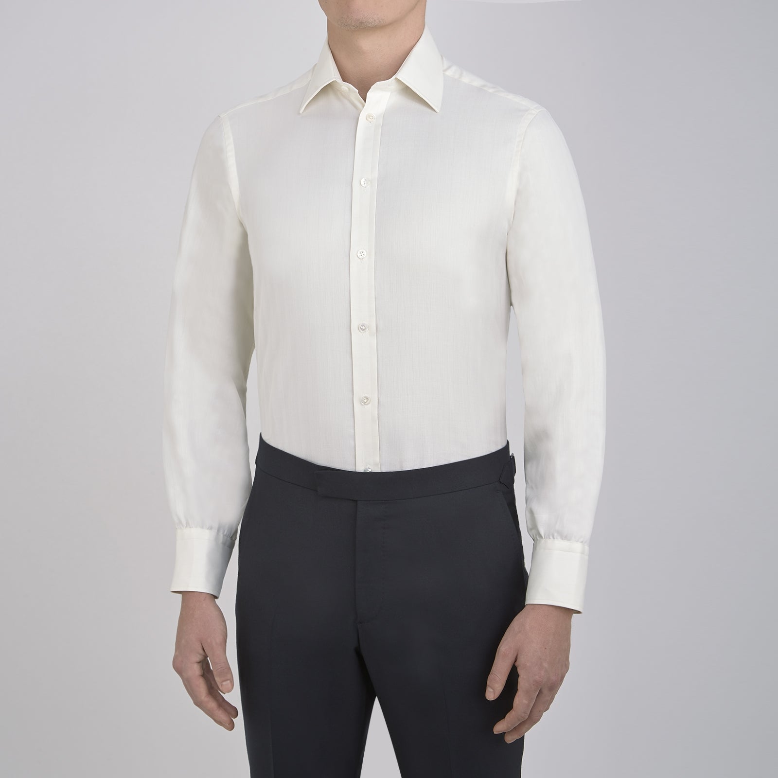 View 2 of product The Turnbull & Asser Cream Herringbone Superfine Cotton Shirt features a T&A collar and 3-button cuffs, ideal for minimalist style or bold ties, shown neatly folded against a plain white background.