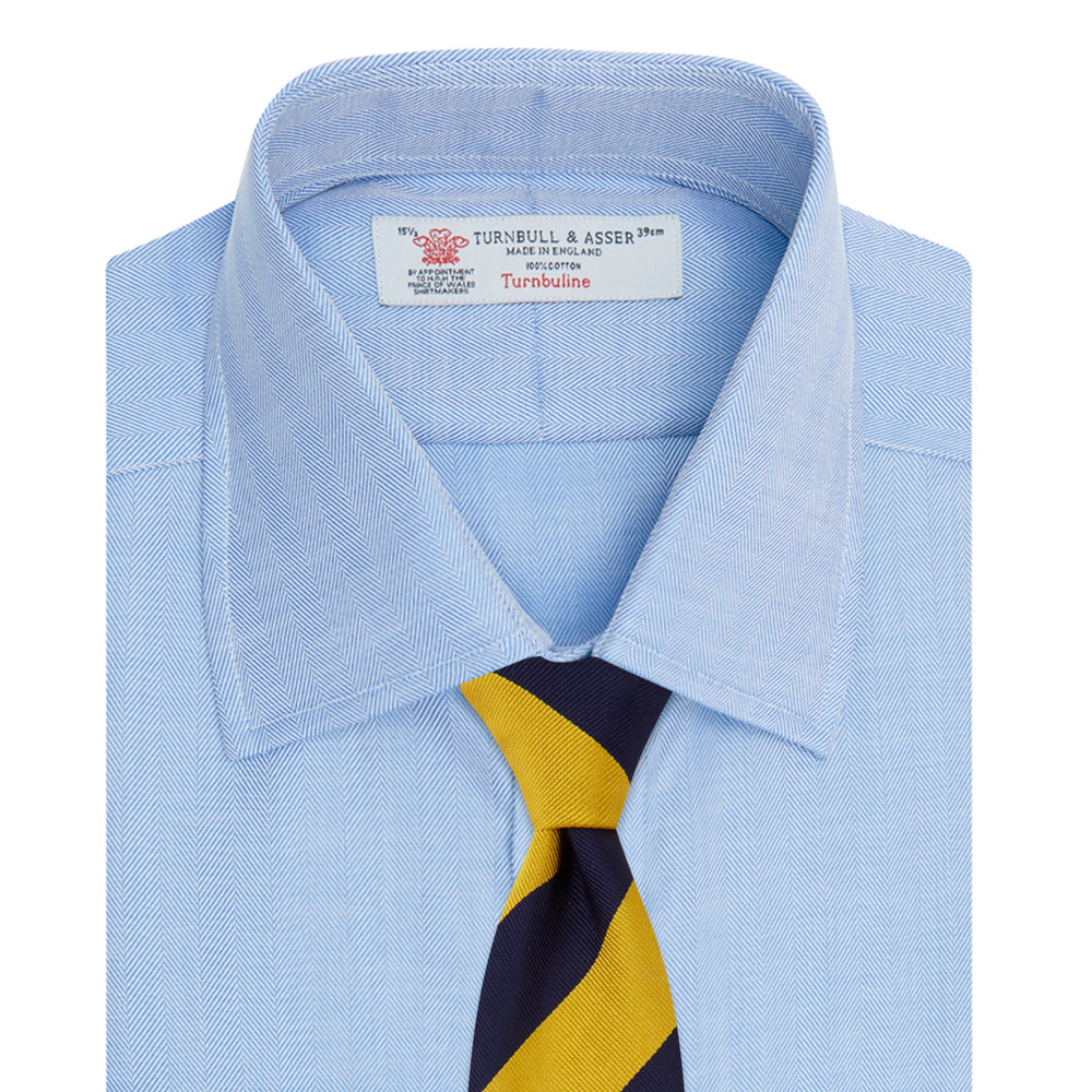 The Turnbull & Asser Blue Herringbone Superfine Cotton Shirt features a T&A collar and double cuffs—an essential for discerning gentlemen—shown folded on a plain white background.