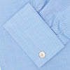 View 6 of product The Turnbull & Asser Blue Herringbone Superfine Cotton Shirt features a T&A collar and double cuffs—an essential for discerning gentlemen—shown folded on a plain white background.