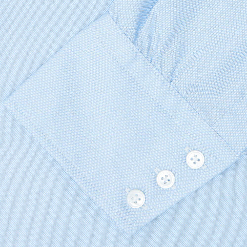 Turnbull & Asser's Light Blue Royal Oxford Cotton Shirt features a button-down collar, 3-button cuffs, and white buttons. Men's shirt comes neatly folded, with a branded neck label displaying garment details—ideal under a navy suit.