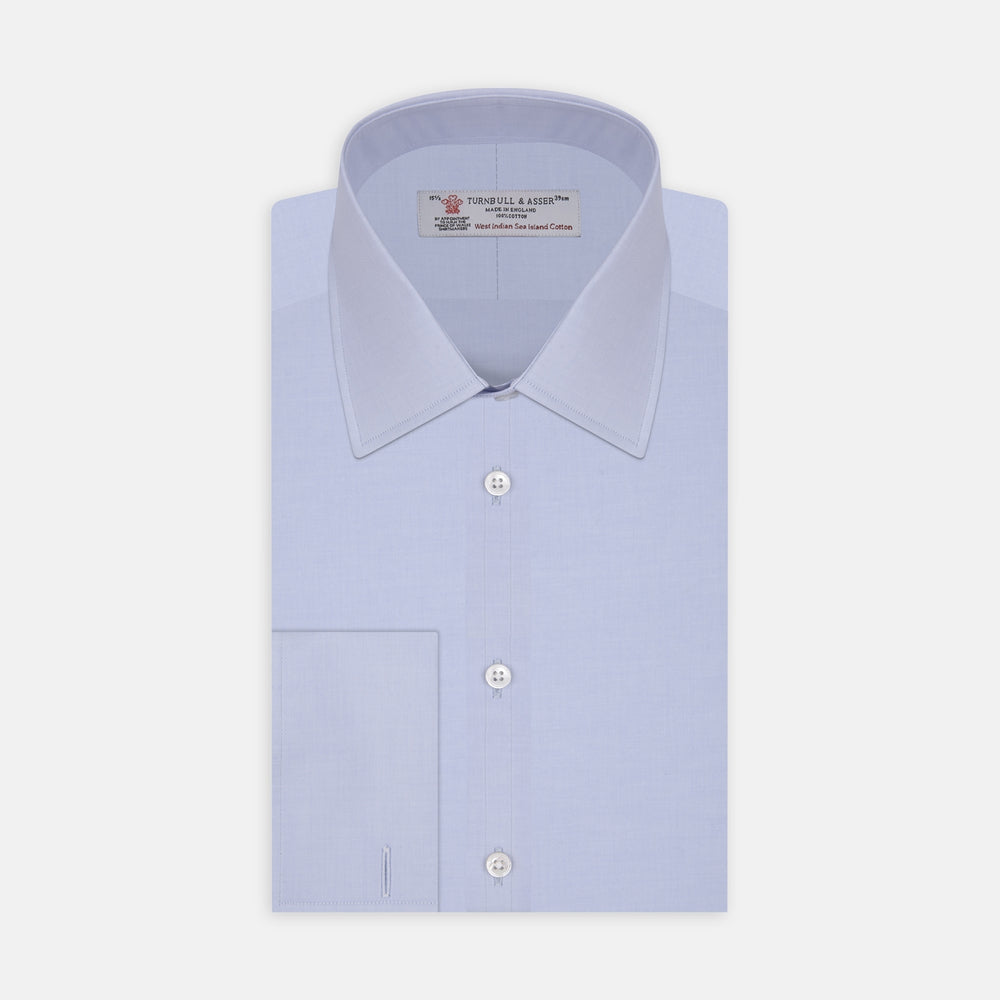 A neatly folded light blue long-sleeve dress shirt with a pointed collar and white buttons, styled with the Turnbull & Asser Monochrome Paisley Mill Silk Pocket Square (limited edition), displayed against a plain white background.