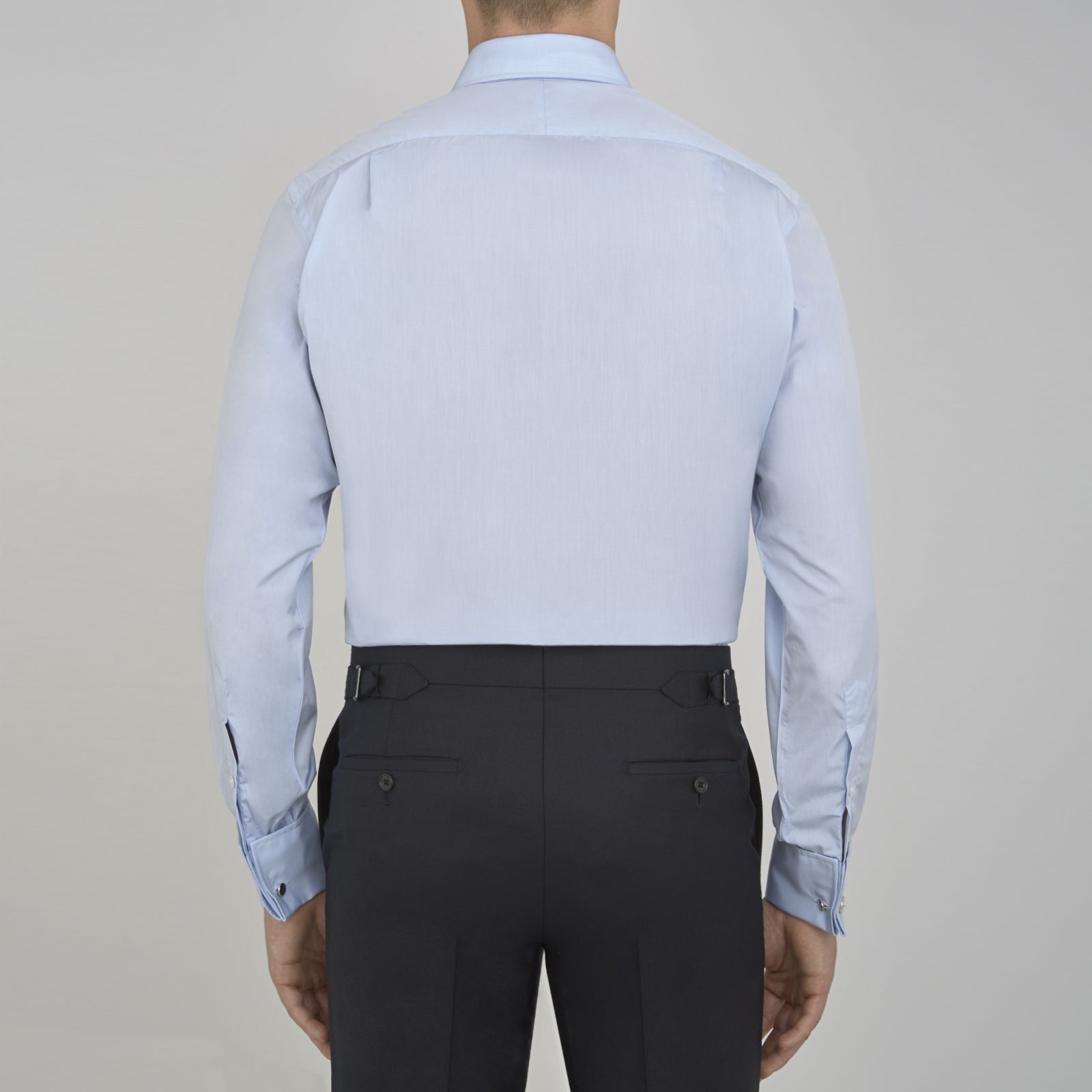View 3 of product A neatly folded light blue long-sleeve dress shirt with a pointed collar and white buttons, styled with the Turnbull & Asser Monochrome Paisley Mill Silk Pocket Square (limited edition), displayed against a plain white background.