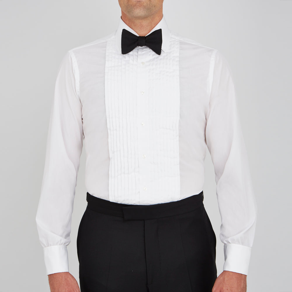 The Turnbull & Asser White Sea Island Quality Cotton Dress Shirt features a T&A collar and double cuffs, elegantly displayed on a light gray background.