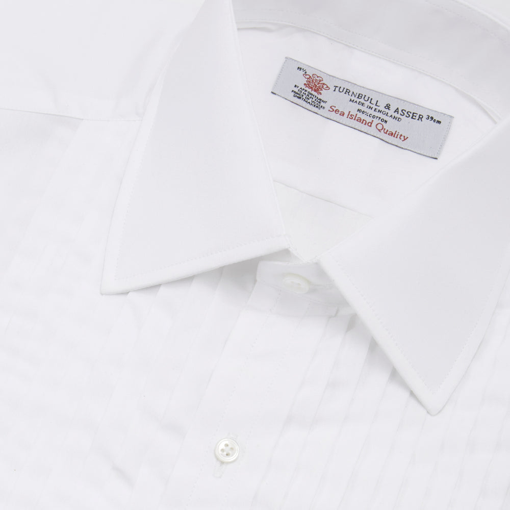 The Turnbull & Asser White Sea Island Quality Cotton Dress Shirt features a T&A collar and double cuffs, elegantly displayed on a light gray background.