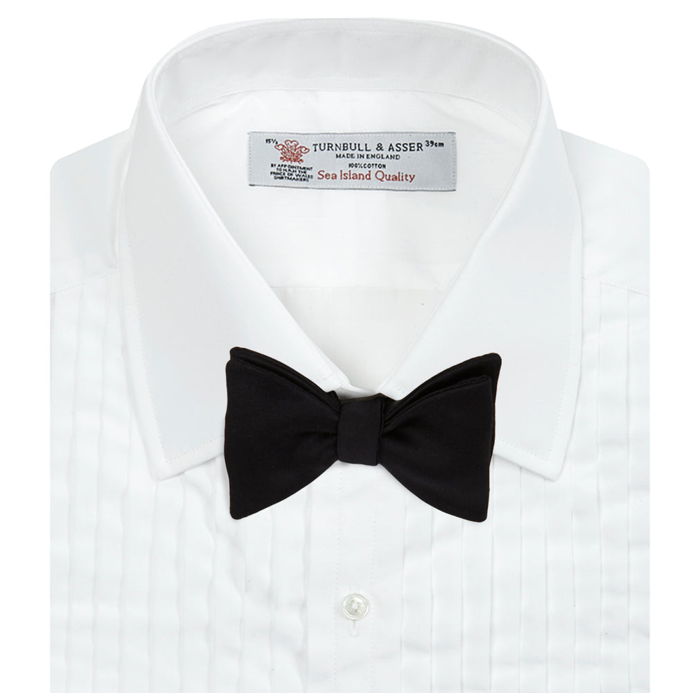 The Turnbull & Asser White Sea Island Quality Cotton Dress Shirt features a T&A collar and double cuffs, elegantly displayed on a light gray background.