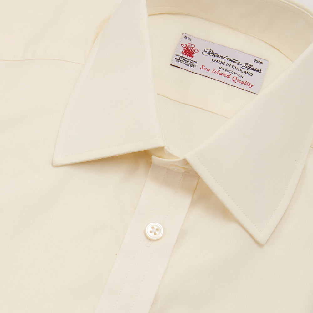 The Cream Sea Island Quality Cotton Shirt by Turnbull & Asser features a T&A collar and 3-button cuffs, crafted from premium cotton and displayed neatly folded against a plain white background.