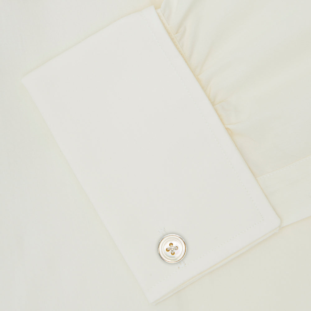 The Turnbull & Asser Cream Sea Island Quality Cotton Shirt features a T&A collar, double cuffs, and a button-down front, elegantly displayed against a white background.