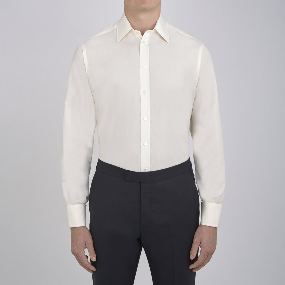 The Turnbull & Asser Cream Sea Island Quality Cotton Shirt features a T&A collar, double cuffs, and a button-down front, elegantly displayed against a white background.