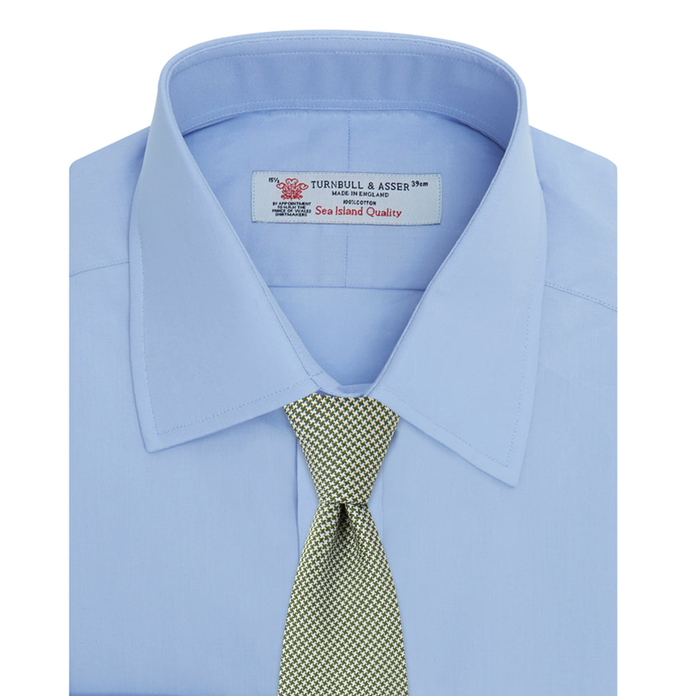 The Turnbull & Asser Blue Sea Island Quality Cotton Shirt features a T&A collar, double cuffs, and is showcased neatly folded on a plain white background.