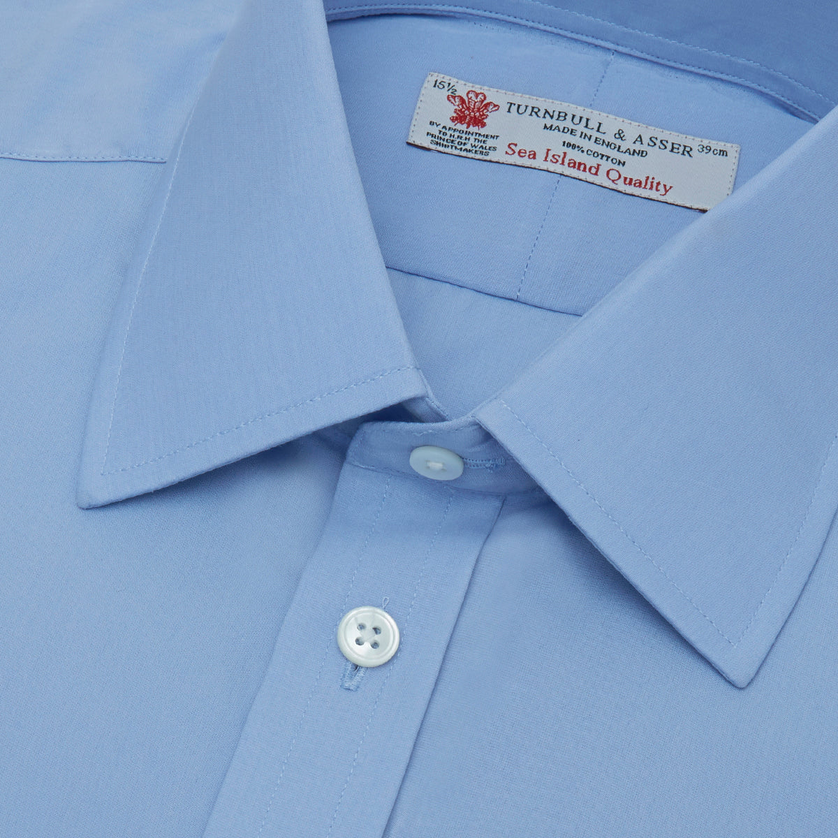 View 5 of product The Turnbull & Asser Blue Sea Island Quality Cotton Shirt features a T&A collar, double cuffs, and is showcased neatly folded on a plain white background.