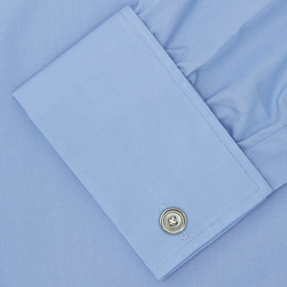 The Turnbull & Asser Blue Sea Island Quality Cotton Shirt features a T&A collar, double cuffs, and is showcased neatly folded on a plain white background.