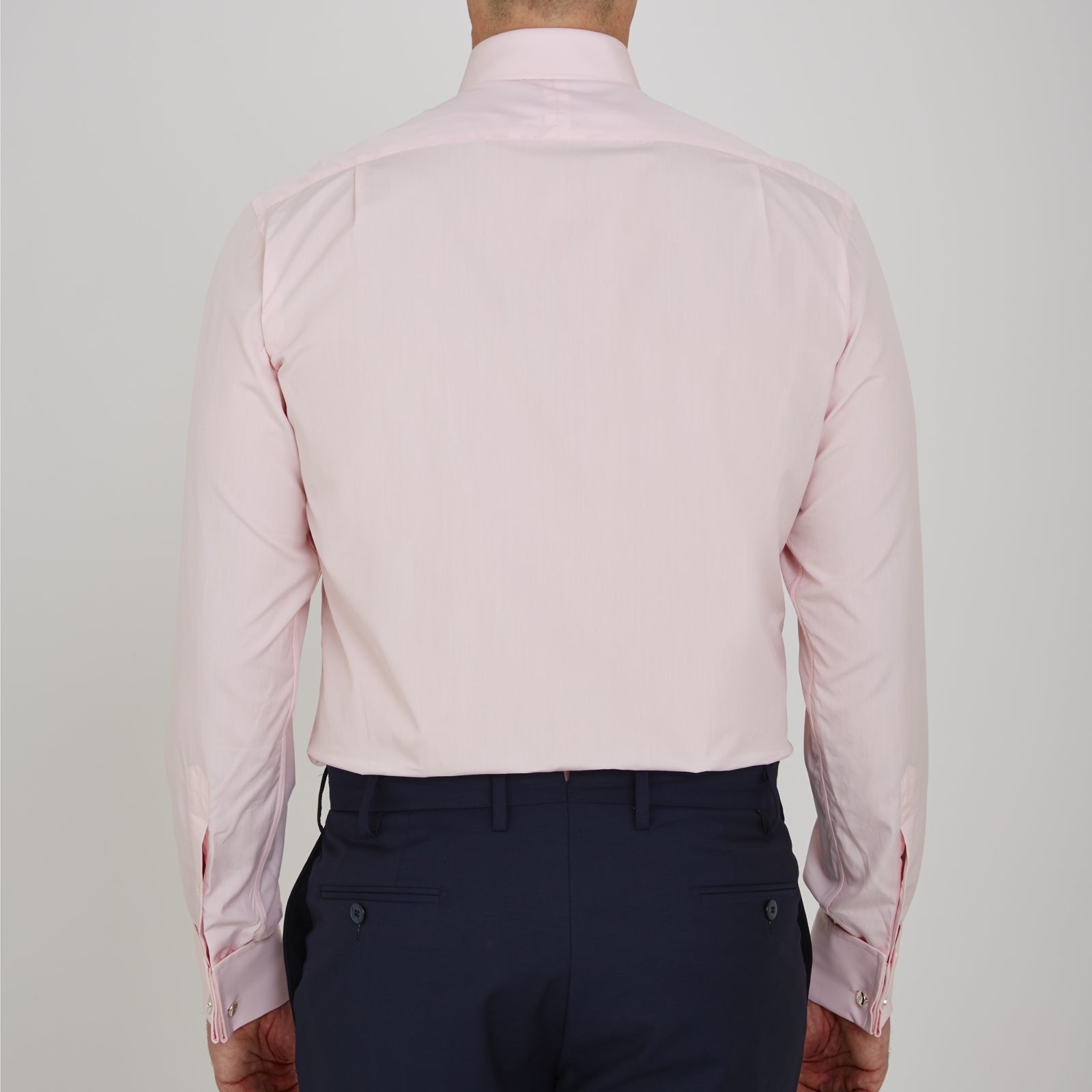 View 3 of product A slim black herringbone silk tie by Turnbull & Asser is paired with a neatly folded light pink long-sleeve dress shirt with a classic collar and white buttons, all displayed on a plain white background.