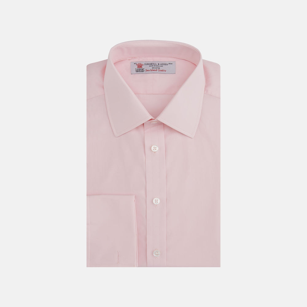 A slim black herringbone silk tie by Turnbull & Asser is paired with a neatly folded light pink long-sleeve dress shirt with a classic collar and white buttons, all displayed on a plain white background.