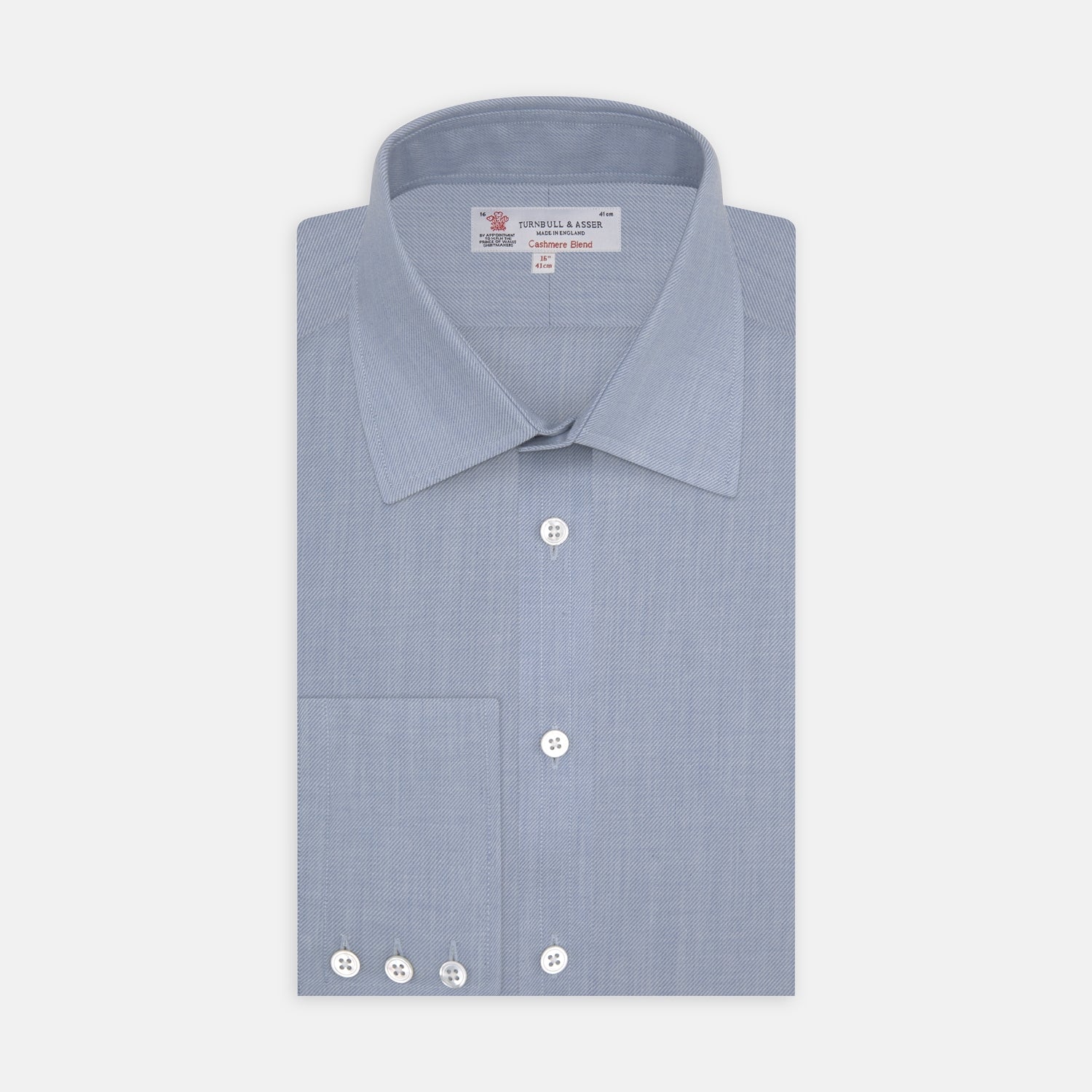 View 1 of product The Turnbull & Asser Blue Cashmere Blend Shirt features a T&A collar and 3-button cuffs, elegantly folded and showcased against a plain white background.