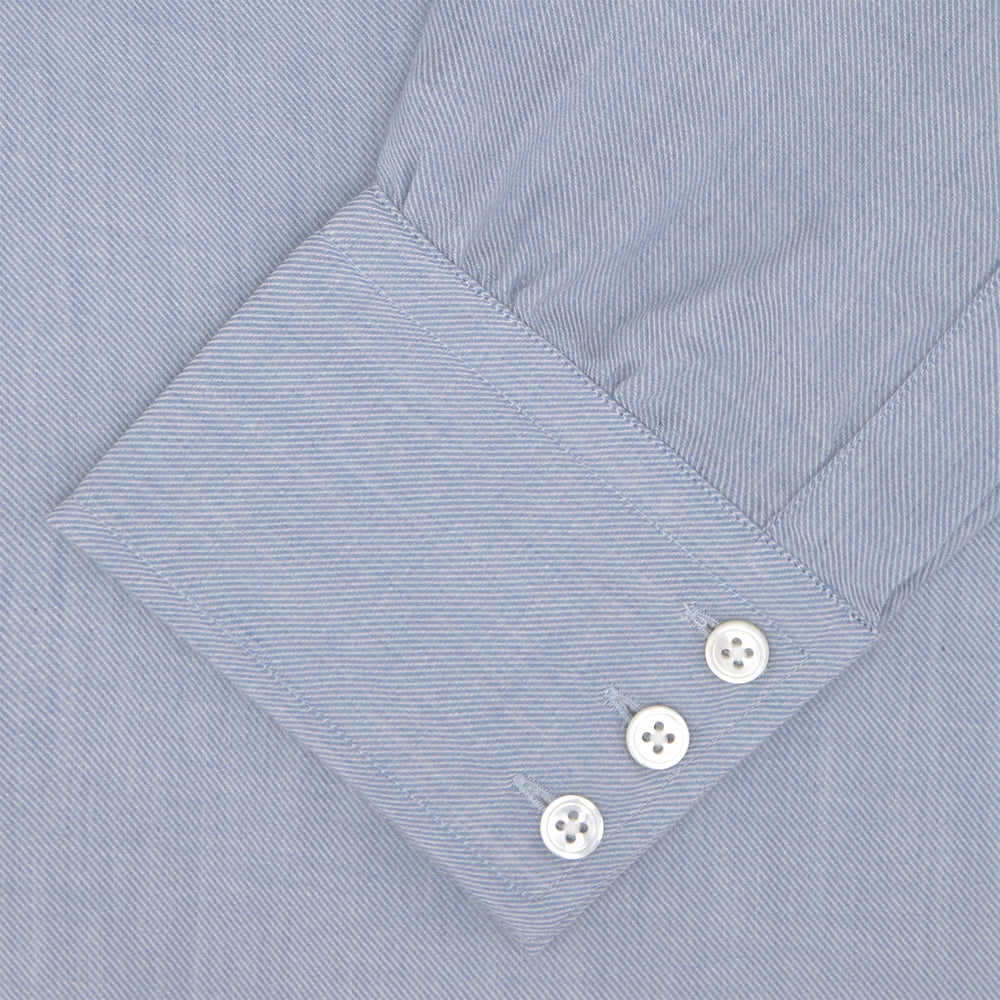 The Turnbull & Asser Blue Cashmere Blend Shirt features a T&A collar and 3-button cuffs, elegantly folded and showcased against a plain white background.