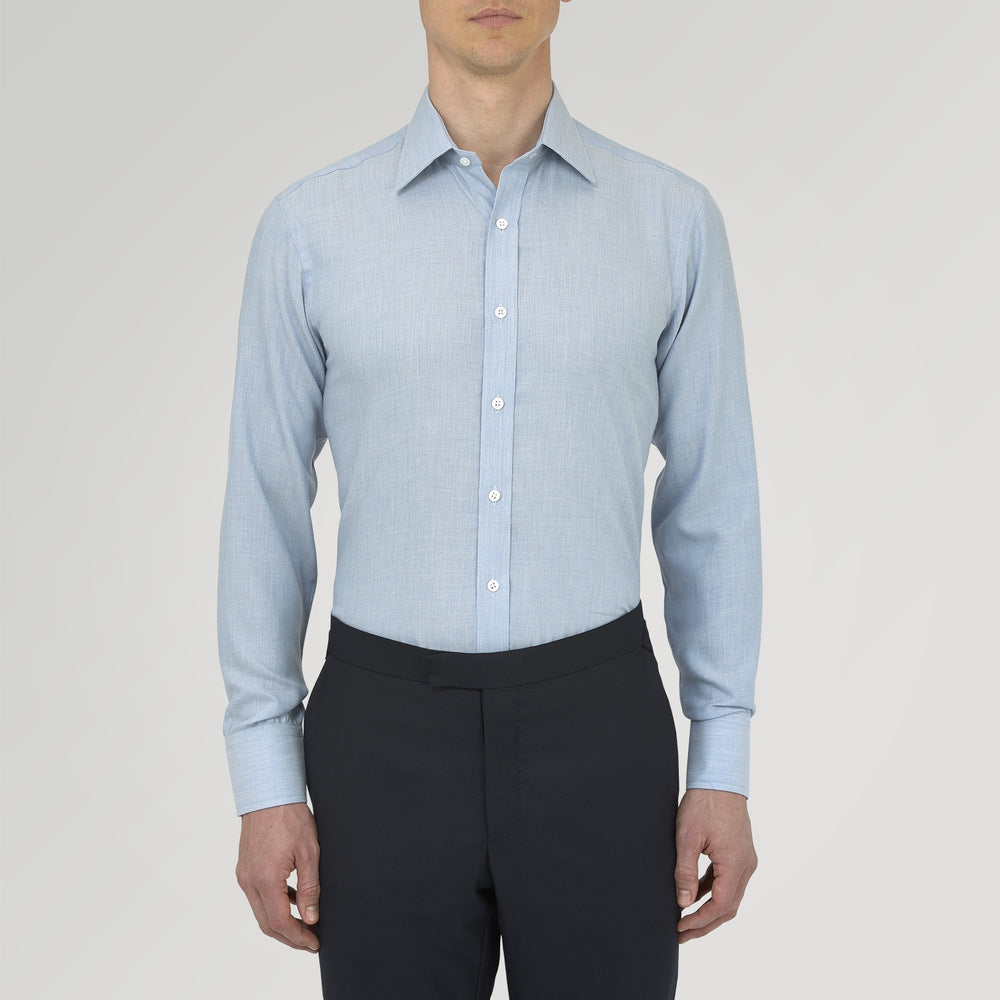 The Turnbull & Asser Blue Cashmere Blend Shirt features a T&A collar and 3-button cuffs, elegantly folded and showcased against a plain white background.