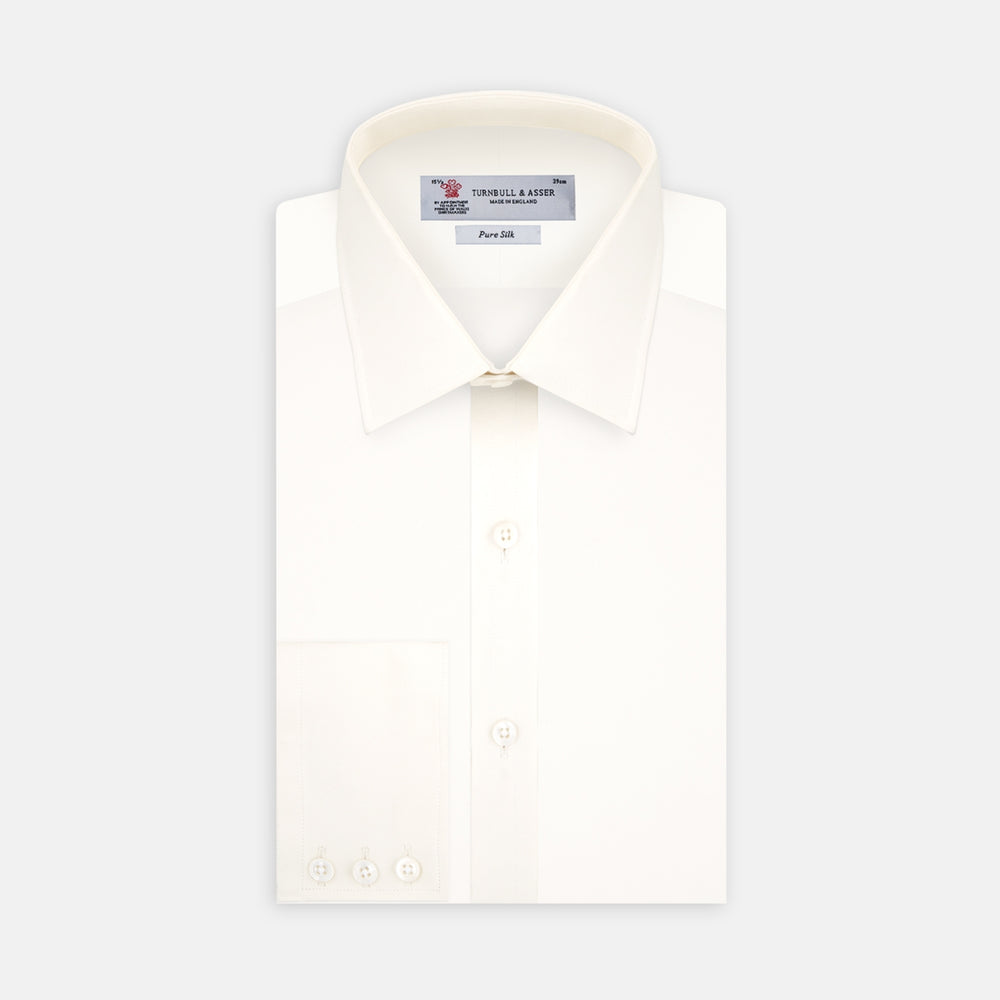 The Cream Silk Shirt by Turnbull & Asser features a T&A collar and 3-button cuffs, displayed folded on a light background—perfect for sophisticated evening wear.