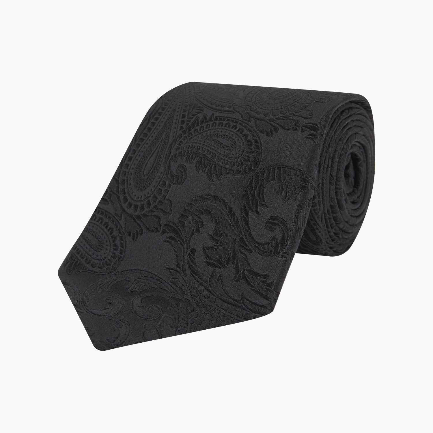View 1 of product The Black Paisley Silk Tie by Turnbull & Asser features an elegant swirling paisley design with a subtle sheen—an all-black statement accessory photographed rolled up on a white background.