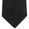 View 4 of product The Black Paisley Silk Tie by Turnbull & Asser features an elegant swirling paisley design with a subtle sheen—an all-black statement accessory photographed rolled up on a white background.