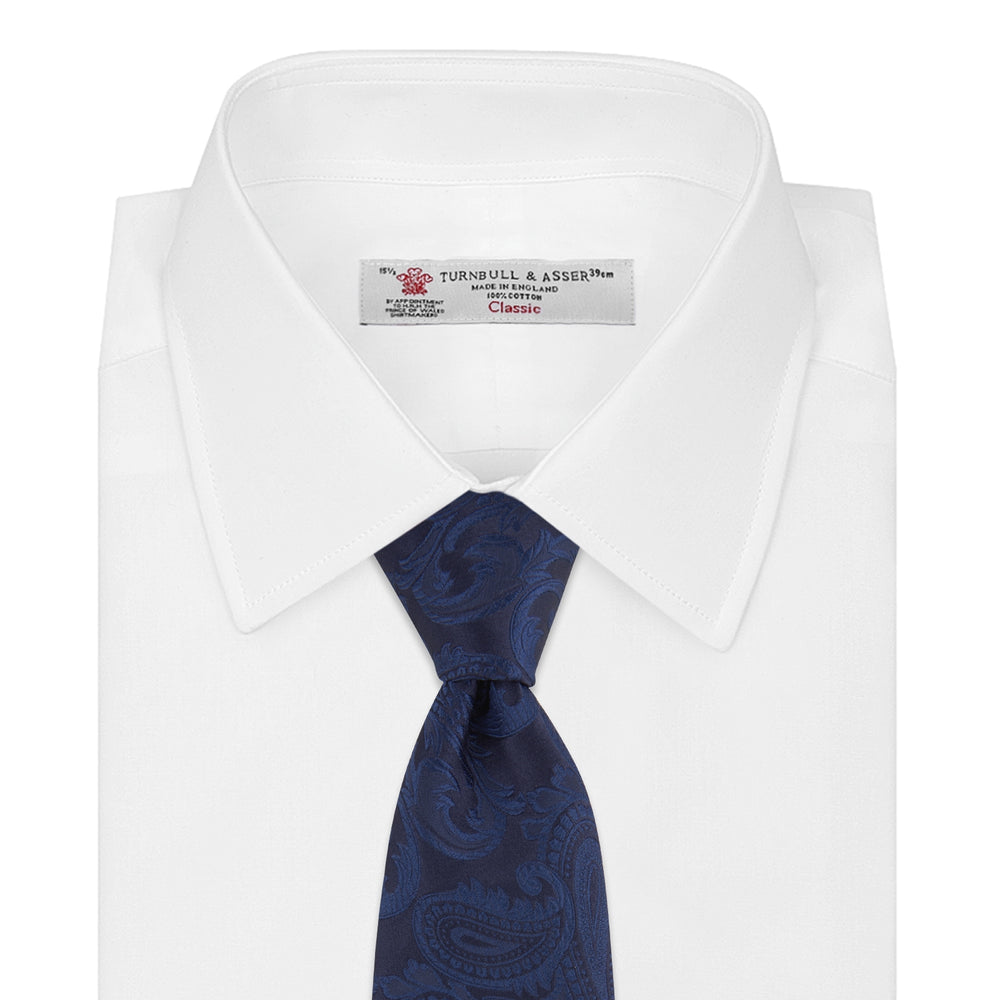 The Navy Paisley Silk Tie by Turnbull & Asser is a classic men's accessory in blue and black, adding sophistication to any look.