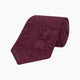 The Turnbull & Asser Burgundy Paisley Silk Tie, showcased rolled on a white background, is an elegant statement piece featuring a refined paisley design for any wardrobe.