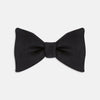 View 1 of product The Turnbull & Asser Black Satin Bow Tie features a classic, neatly tied shape, displayed on a white background—a sophisticated accessory for formal attire.