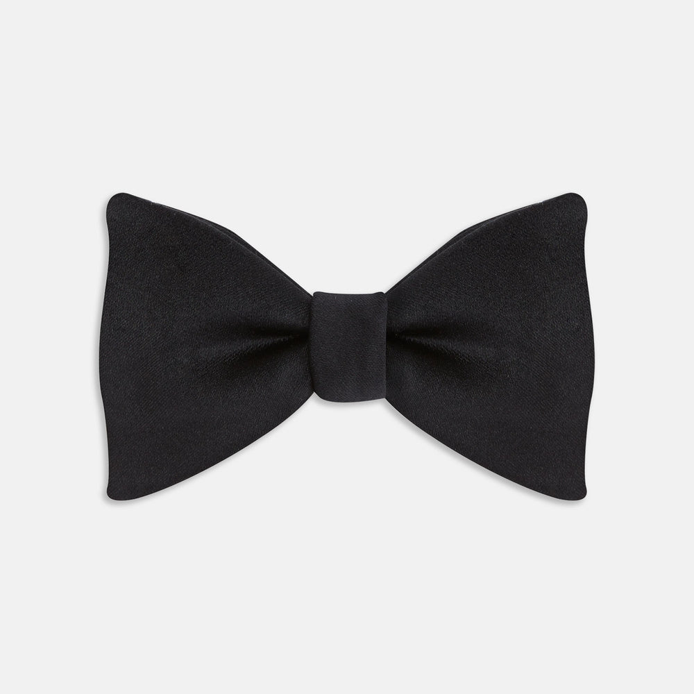 The Turnbull & Asser Black Satin Bow Tie features a classic, neatly tied shape, displayed on a white background—a sophisticated accessory for formal attire.