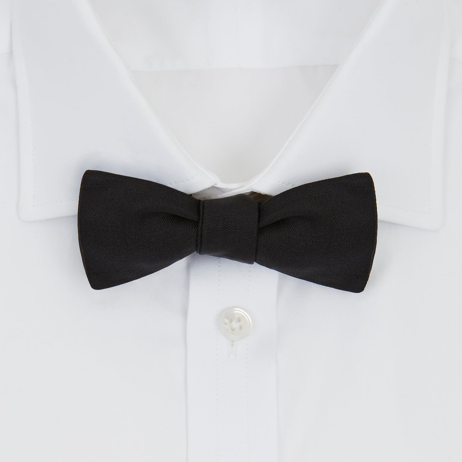 View 2 of product The Black Narrow Silk Bow Tie by Turnbull & Asser features a classic slim design with a matte finish, neatly tied and centered on a plain white background—perfect for formal occasions.