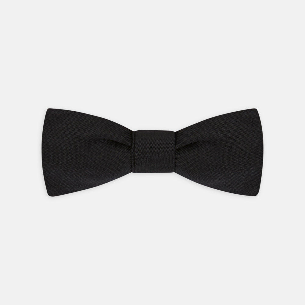 The Black Narrow Silk Bow Tie by Turnbull & Asser features a classic slim design with a matte finish, neatly tied and centered on a plain white background—perfect for formal occasions.