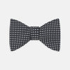 View 1 of product The Turnbull & Asser Diamond Black and White Silk Bow Tie features a black woven silk design with a tessellated diamond pattern of small white shapes, shown against a plain white background.