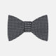The Turnbull & Asser Diamond Black and White Silk Bow Tie features a black woven silk design with a tessellated diamond pattern of small white shapes, shown against a plain white background.