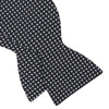 View 4 of product The Turnbull & Asser Diamond Black and White Silk Bow Tie features a black woven silk design with a tessellated diamond pattern of small white shapes, shown against a plain white background.