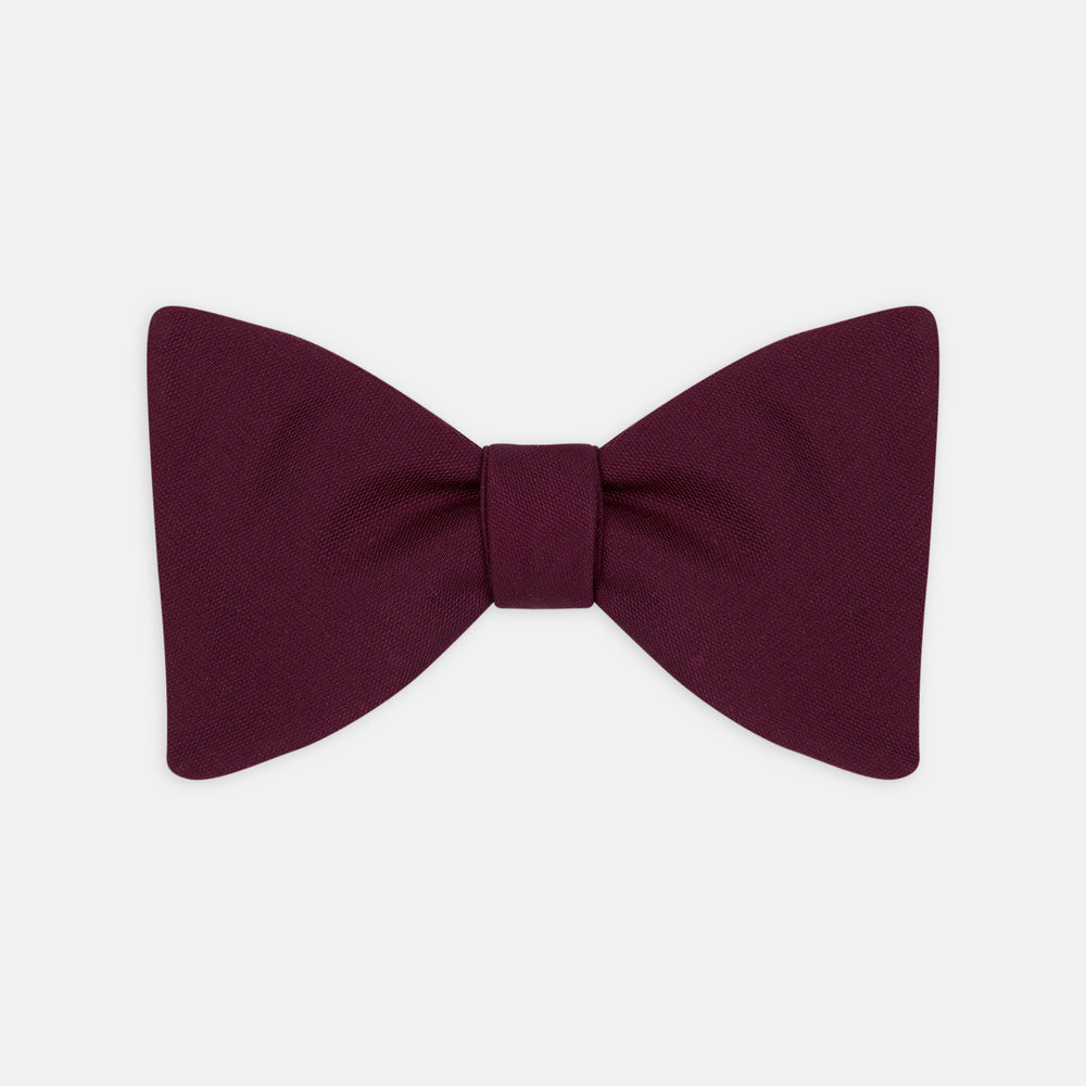 The Turnbull & Asser Burgundy Barathea Bow Tie, shown neatly tied with pointed ends on a white background, features smooth matte fabric for a refined formal look.