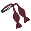 View 3 of product The Turnbull & Asser Burgundy Barathea Bow Tie, shown neatly tied with pointed ends on a white background, features smooth matte fabric for a refined formal look.