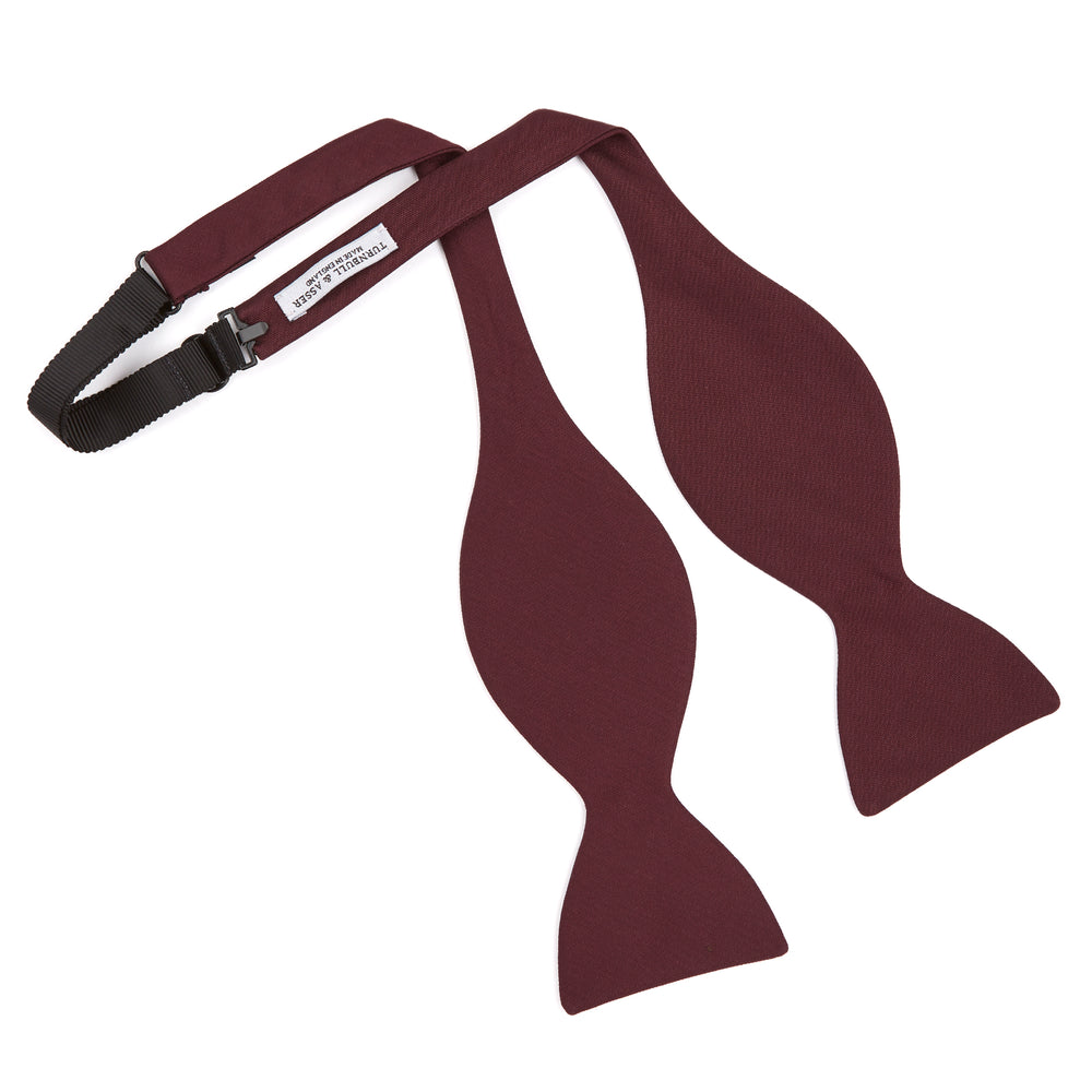 The Turnbull & Asser Burgundy Barathea Bow Tie, shown neatly tied with pointed ends on a white background, features smooth matte fabric for a refined formal look.