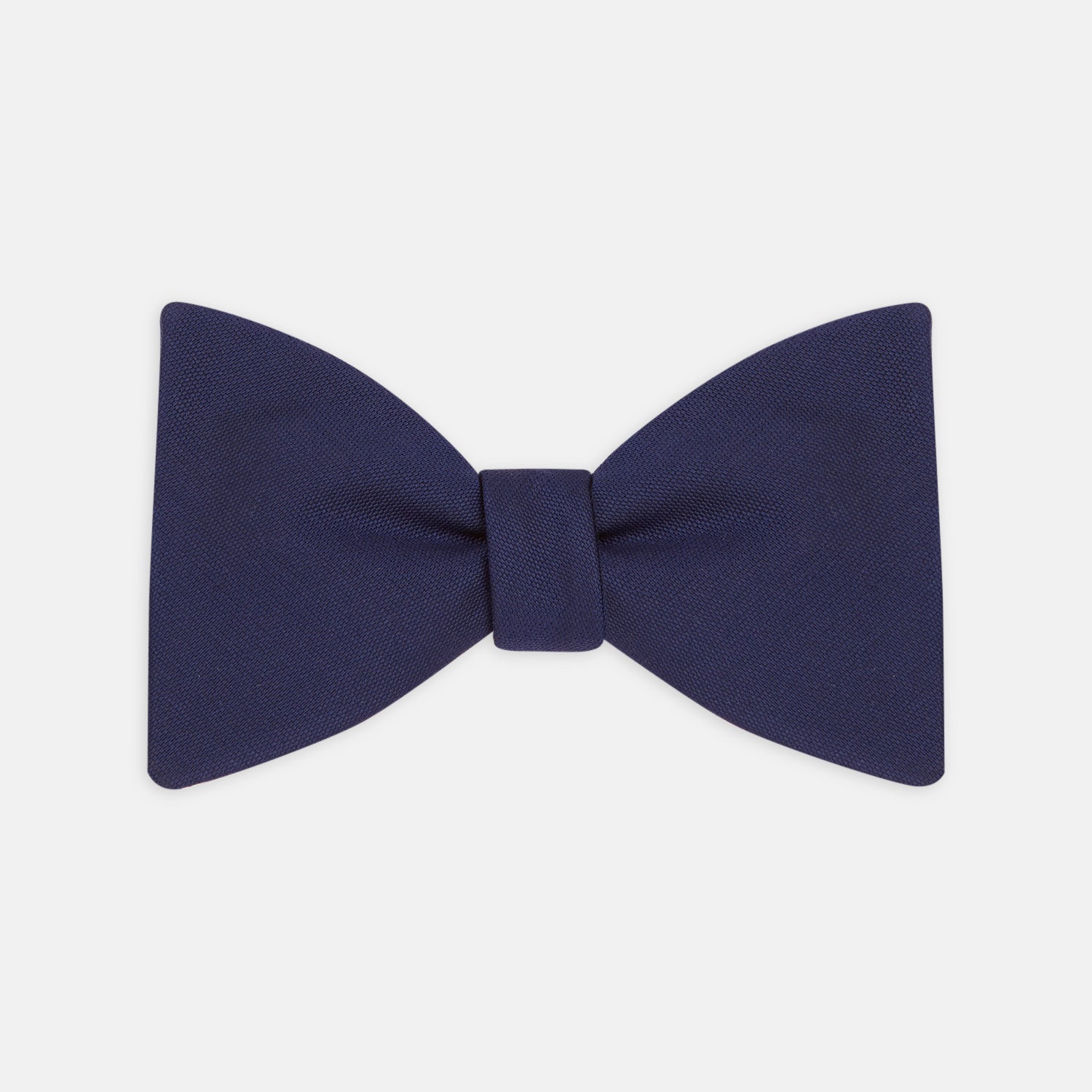 View 1 of product The Turnbull & Asser Navy Barathea Bow Tie features a classic butterfly shape in deep blue silk, ideal for formal occasions, shown against a white background.