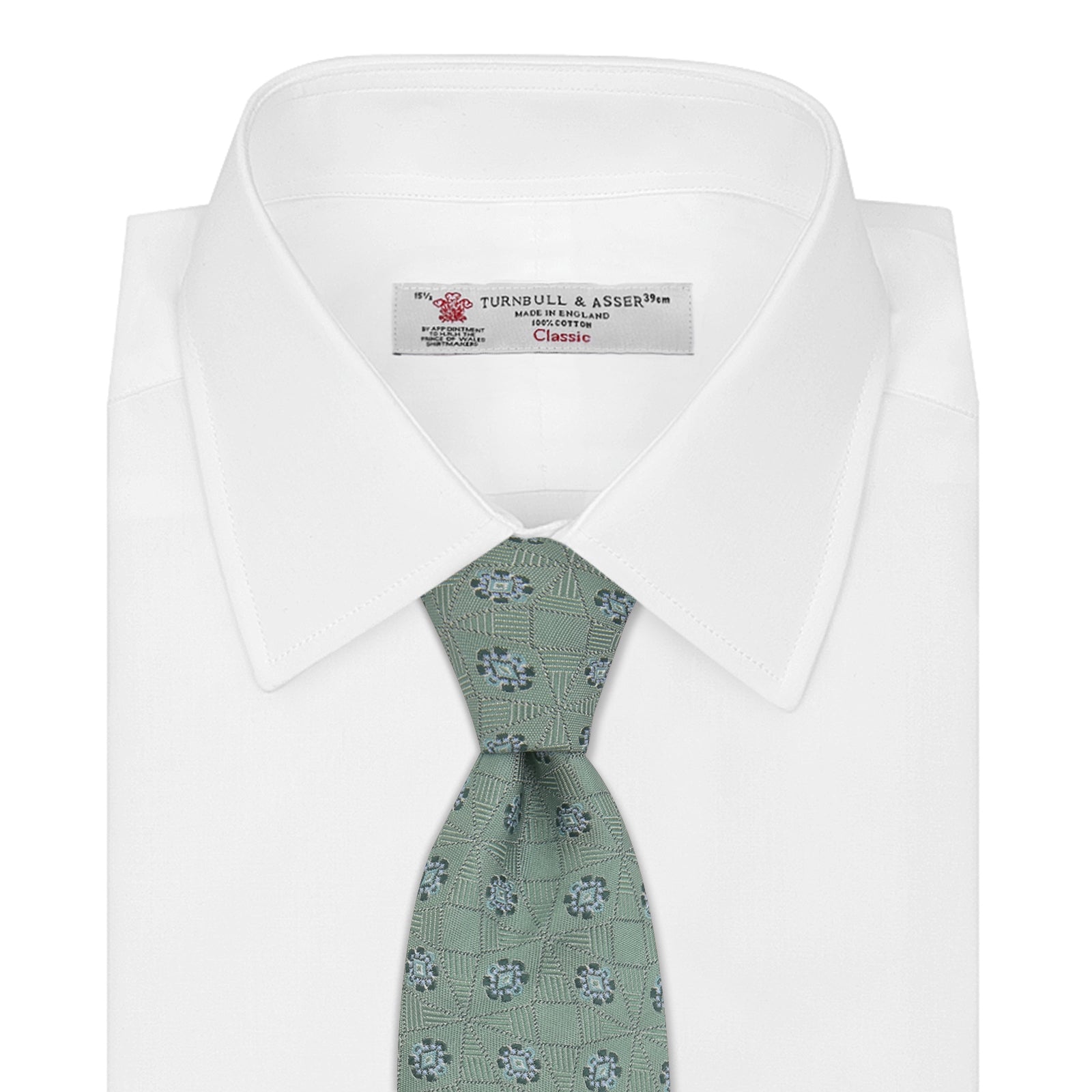 View 2 of product The Turnbull & Asser Green Star Flowers Silk Tie features a light green jacquard with a subtle checkered pattern and small blue star flower motifs, shown rolled up on a white background.
