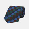 View 1 of product The Turnbull & Asser Navy and Blue Checkerboard Jacquard Wool Tie showcases a stylish checkered pattern, ideal for adding refined autumn tones to your ensemble.