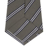 View 4 of product The Turnbull & Asser Grey Diagonal Stripe Cotton and Silk Tie features a navy, grey, and white striped pattern and is shown rolled up against a plain white background.
