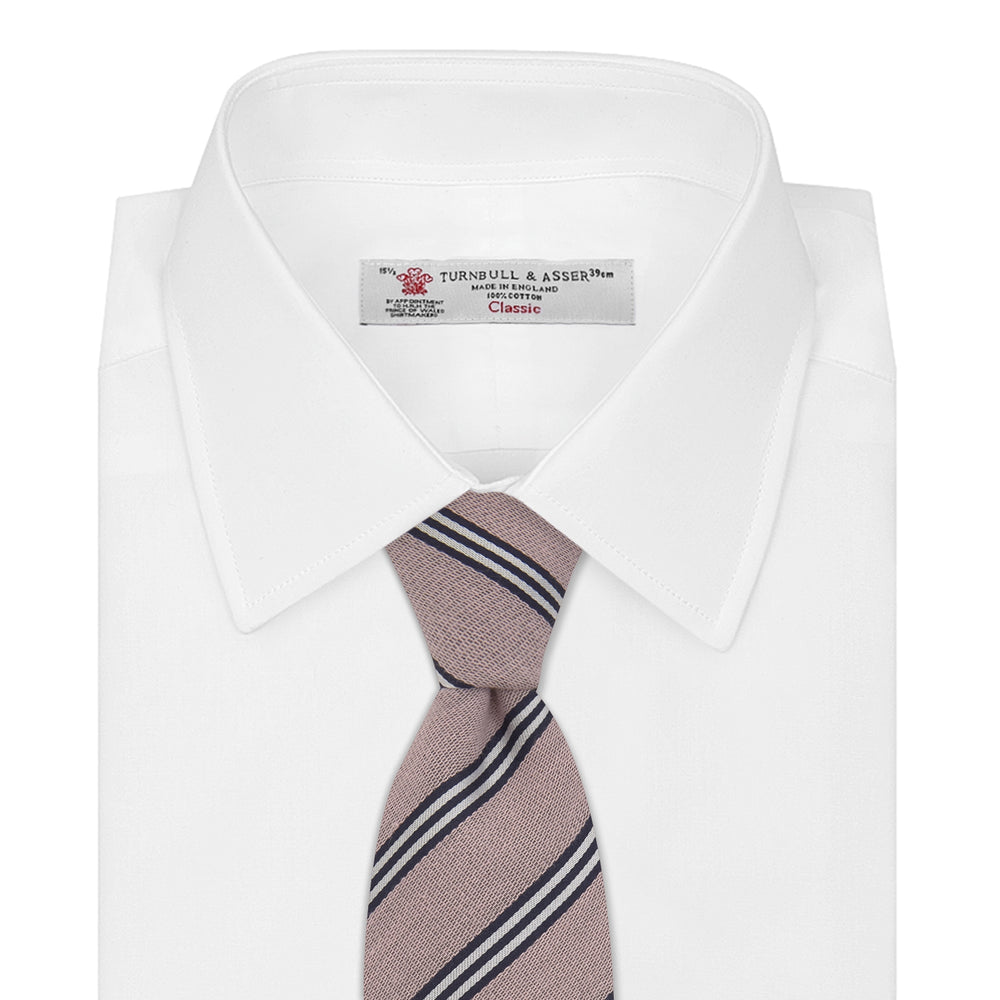 The Turnbull & Asser Pastel Pink Diagonal Stripe Cotton and Silk Tie, featuring navy blue and white stripes, is neatly rolled against a plain white background.