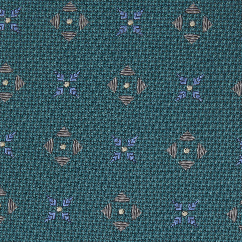 The Turquoise Crosses Silk Tie by Turnbull & Asser features a subtle geometric motif in tan and blue, displayed rolled on a white background—ideal for the modern office.