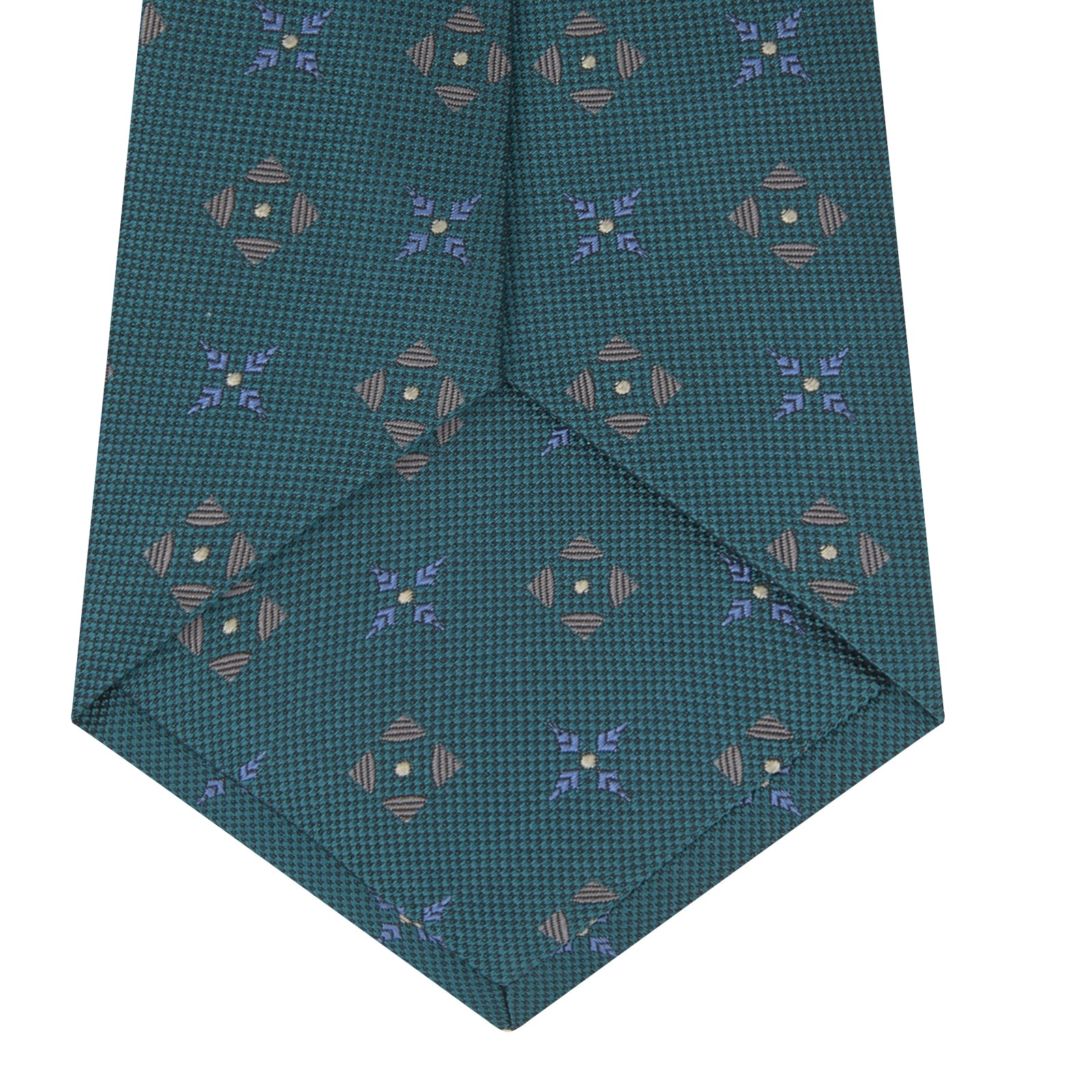 View 4 of product The Turquoise Crosses Silk Tie by Turnbull & Asser features a subtle geometric motif in tan and blue, displayed rolled on a white background—ideal for the modern office.