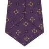 View 4 of product The Turnbull & Asser Purple Crosses Silk Tie features a rolled-up purple design with small yellow and black cross motifs on silk.