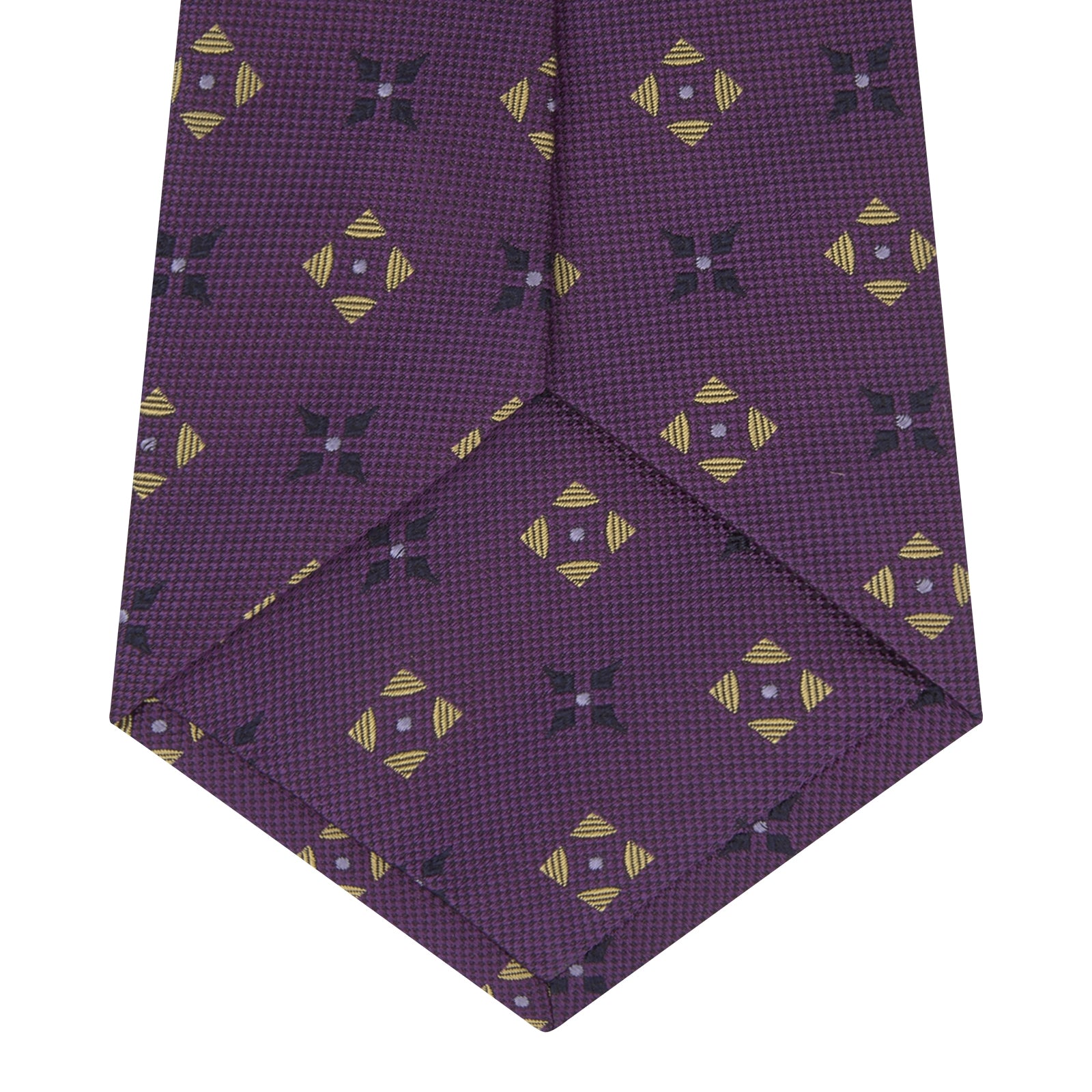 View 4 of product The Turnbull & Asser Purple Crosses Silk Tie features a rolled-up purple design with small yellow and black cross motifs on silk.