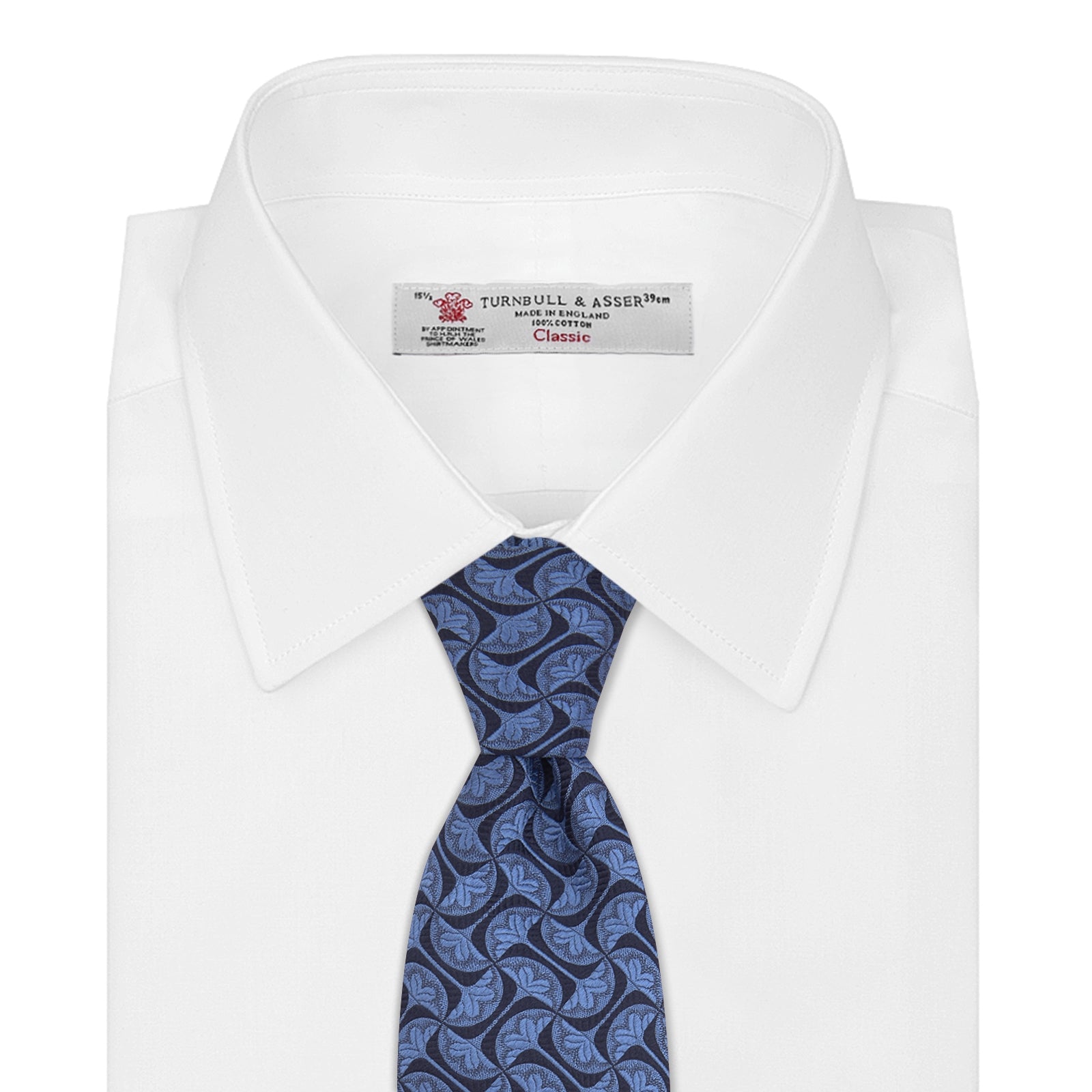 View 2 of product The Turnbull & Asser Blue Geo Silk Tie features a refined blue silk with a light blue abstract leaf pattern in a geometric design, rolled at one end and shown on a plain white background.