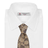 View 2 of product The Copper Floral Occasion Silk Tie by Turnbull & Asser features a gold floral jacquard pattern on brown silk, elegantly rolled on a white surface—an ideal choice for weddings.