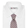 View 2 of product The Turnbull & Asser Pastel Pink Geometric Silk Tie features a small, repeating dark brown and white pattern for a mid-century look—ideal with tailored jackets. Shown rolled up on a white background.