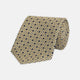 The Turnbull & Asser Pale Yellow Geometric Silk Tie features a subtle navy blue floral pattern and is displayed rolled on a white background.