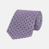 View 1 of product The Turnbull & Asser Lilac Geometric Silk Tie features a small, repeating mid-century motif in dark purple and black on white—an ideal accent for tailored jackets.